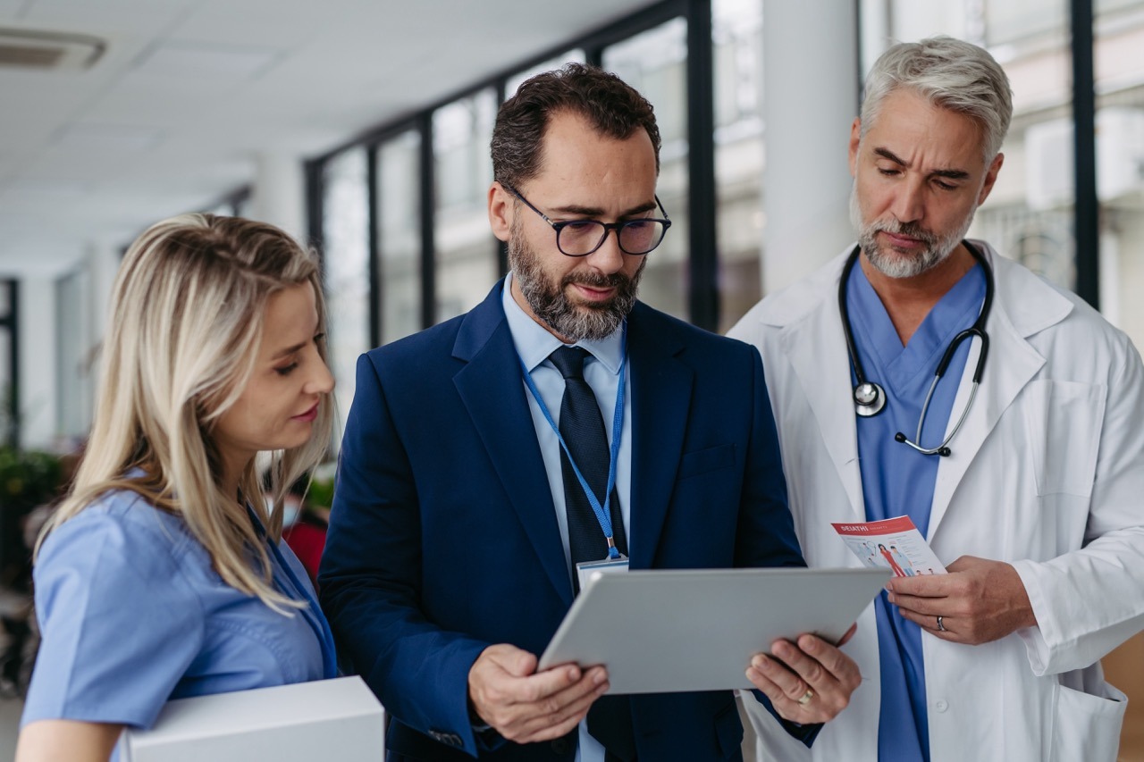 Pharmaceutical,Sales,Representative,Presenting,New,Medication,To,Doctors,In,Medical hospital leadership reviewing downtime preparedness metrics alongside other clinical quality indicators