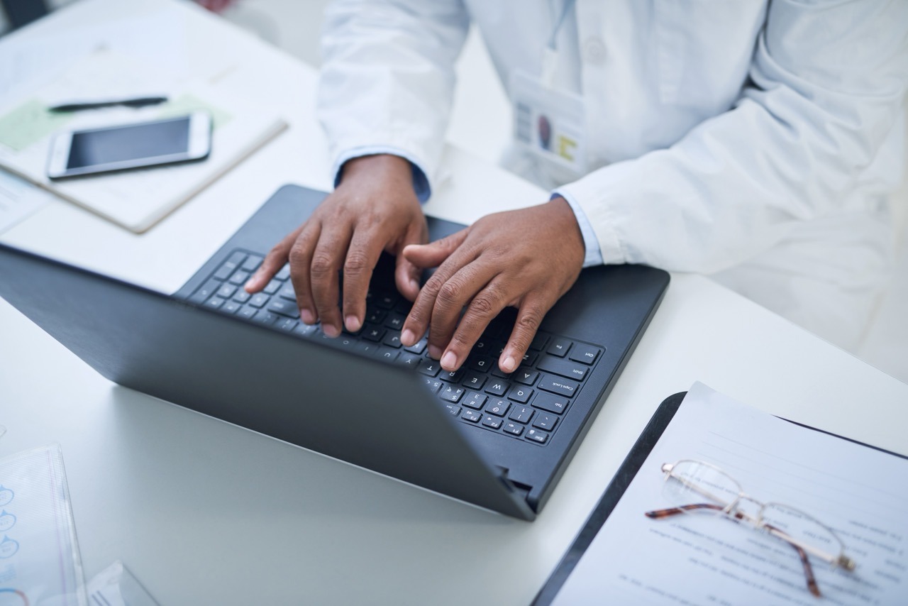 Laptop,,Typing,And,Hands,Of,Scientist,In,Laboratory,For,Medical IT director reviewing a downtime solution RFP checklist covering integration and offline capability questions