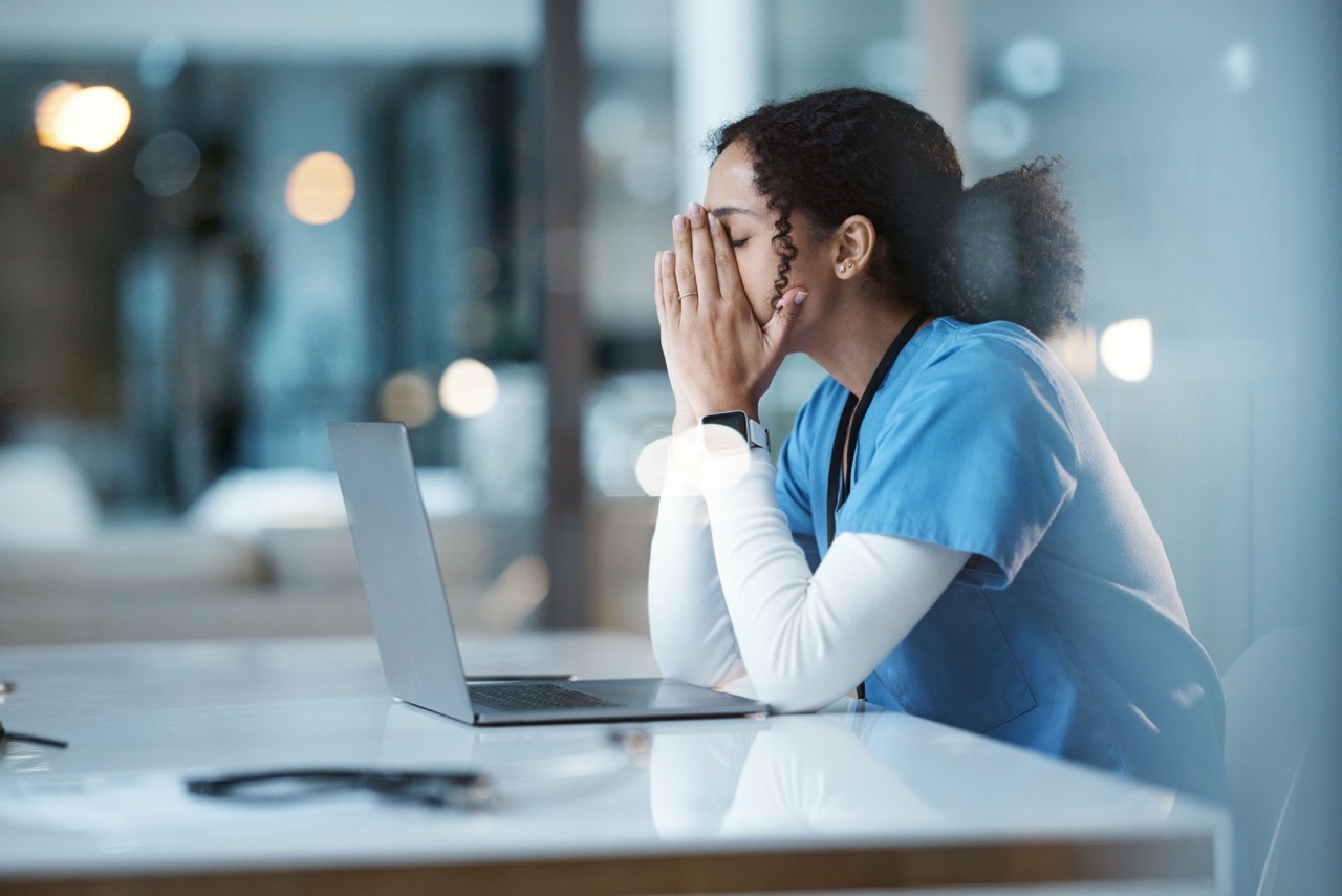 Exhausted nurse managing patient care manually during an EHR downtime event