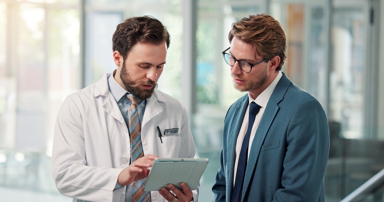 Executives reviewing healthcare M&A due diligence documents for downtime risk