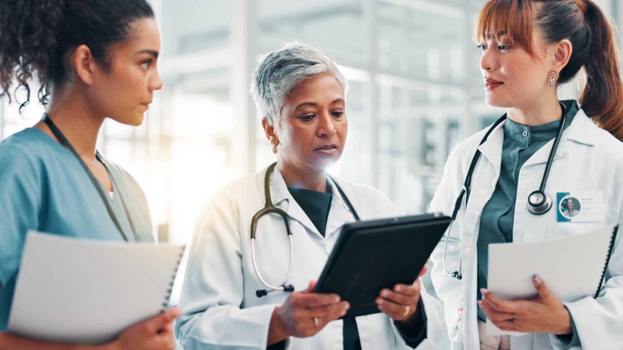 Tablet,,Meeting,And,Team,Of,Doctors,In,Hospital,For,Results, Clinicians reviewing EHR downtime preparedness gaps on a tablet in a hospital