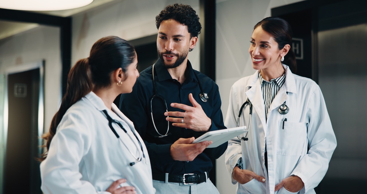 Physicians debriefing on a hospital downtime drill with results on a tablet
